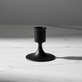 Close up of matte black candle holder on white marble