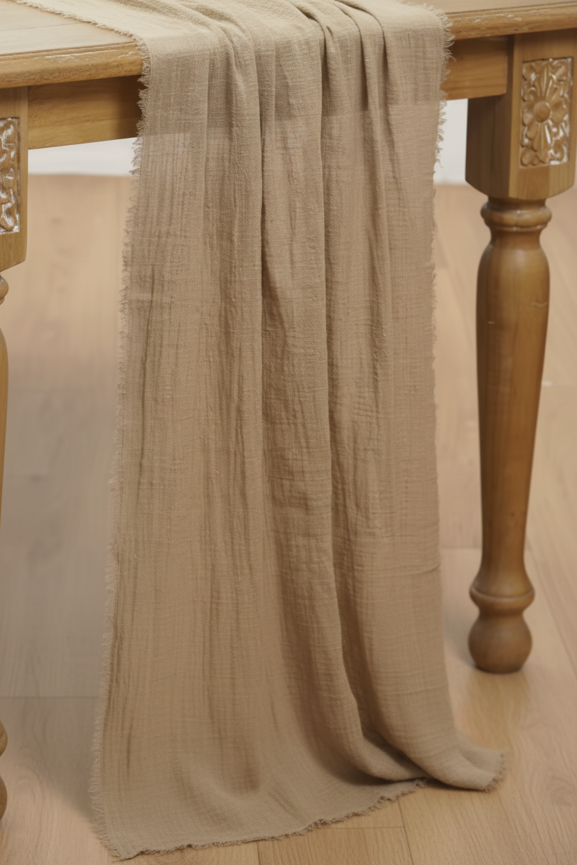 Beige gauze table runner draped over carved wooden table