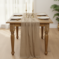 Beige gauze runner on dining table with gold candlesticks